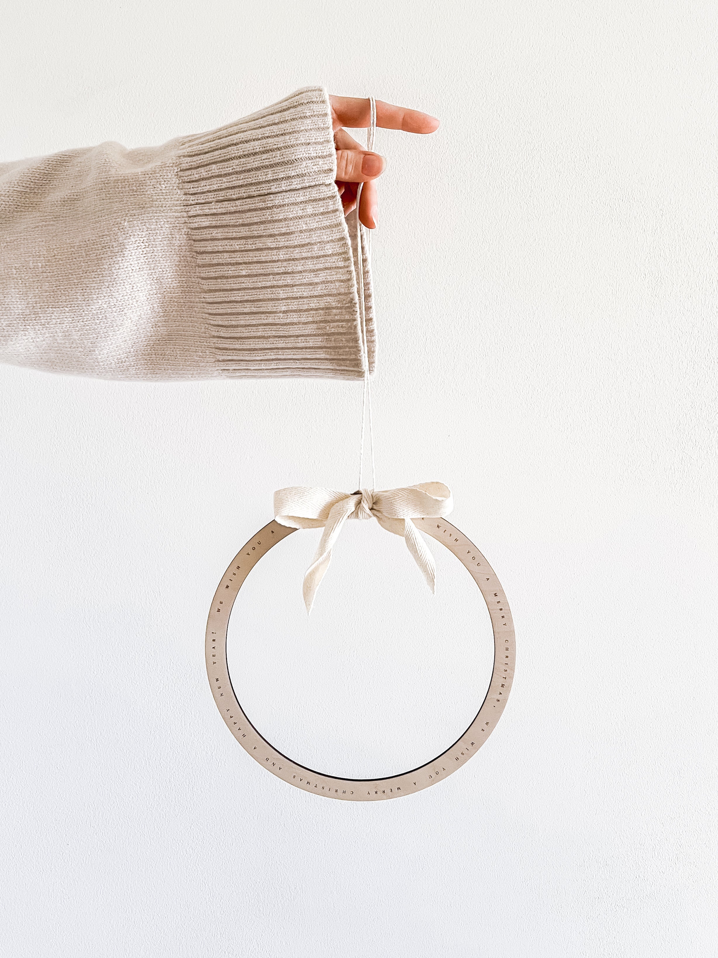 Dekokranz aus Holz als Winterdeko im Eingangsbereich mit feiner Weihnachtsgravur.